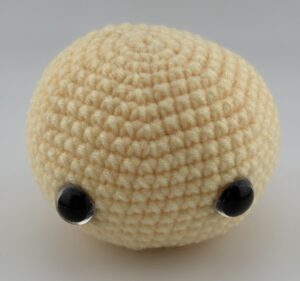 Amigurumi giraffe head crocheted with light yellow yarn and 2 safety eyes 12 mm.
