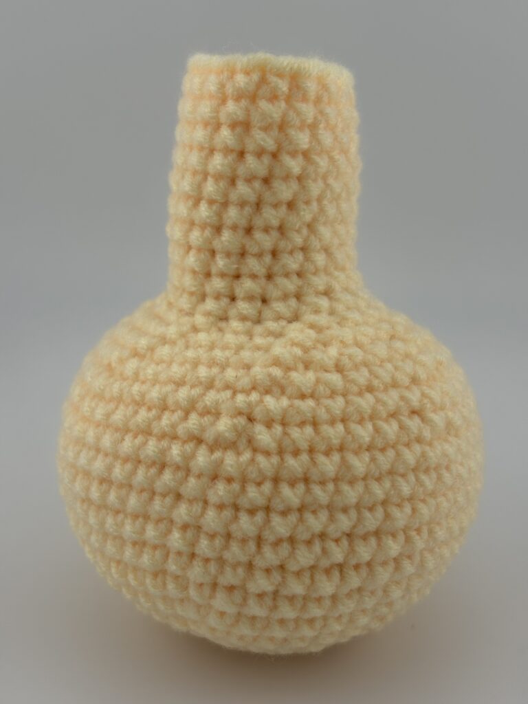 Giraffe body made from light yellow crocheted wool.
