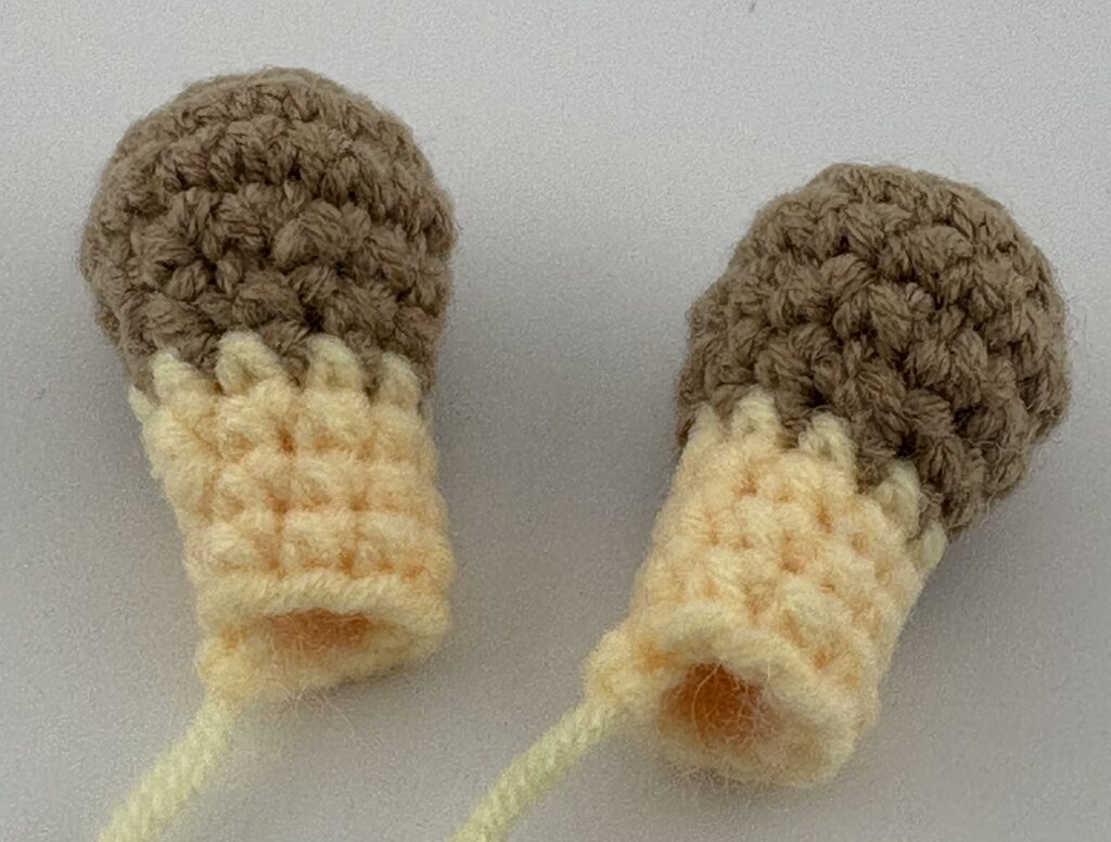 Amigurumi Giraffe horns crocheted with light yellow yarn.