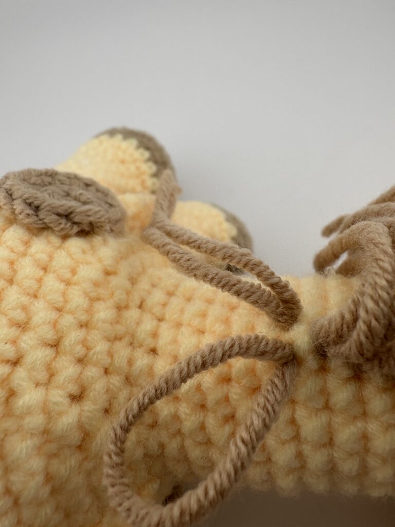 Amigurumi Giraffe crocheted with light yellow yarn and light brown mane.