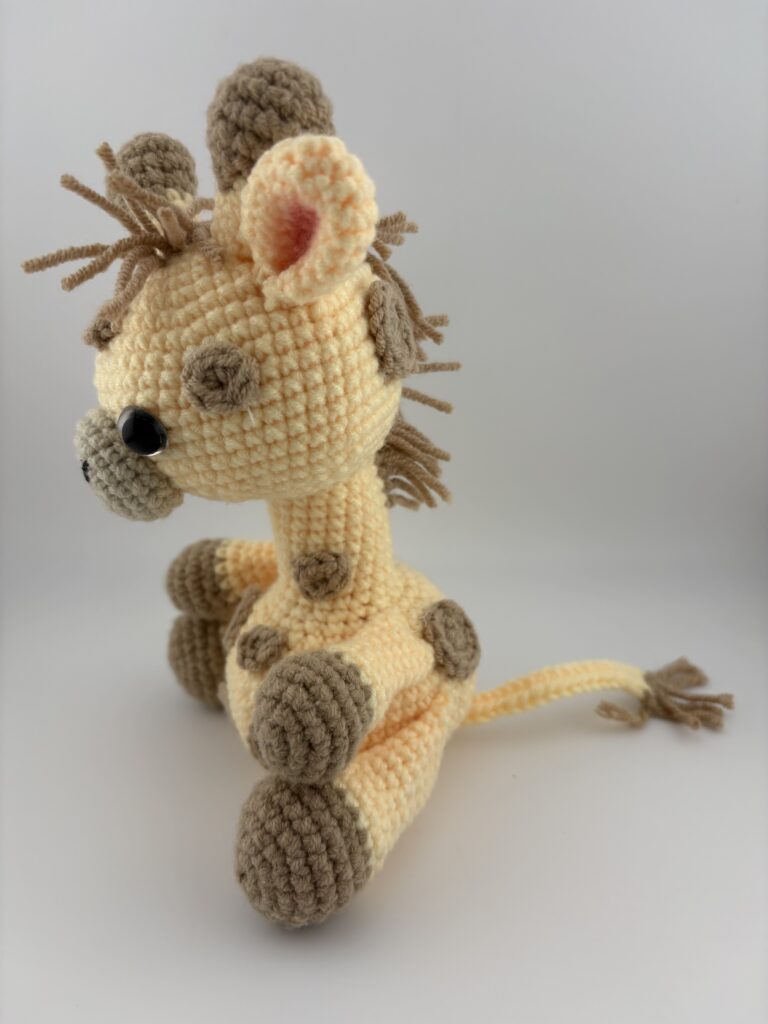 Amigurumi Giraffe crocheted with light yellow yarn with light brown spots and light brown mane.