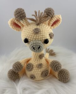 Amigurumi Giraffe crocheted with light yellow yarn and light brown spots.