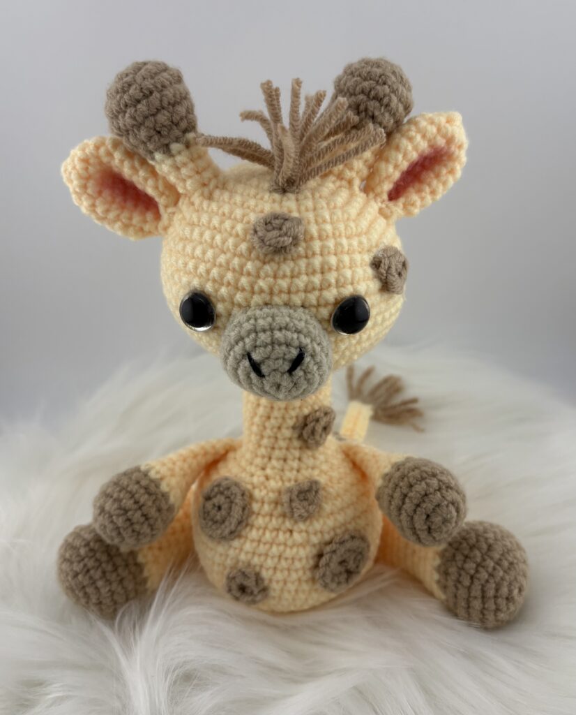 Amigurumi Giraffe crocheted with light yellow yarn and light brown spots.